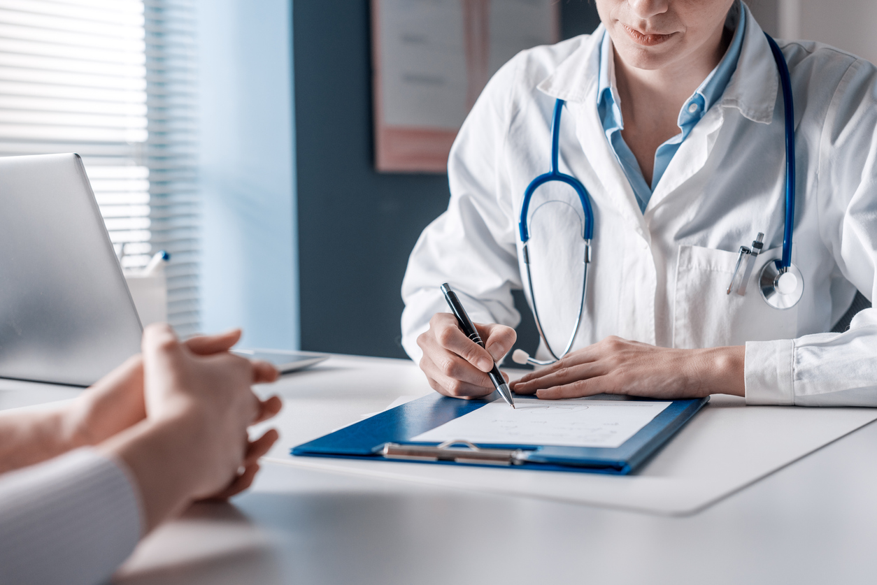 doctor writing a prescription for patient
