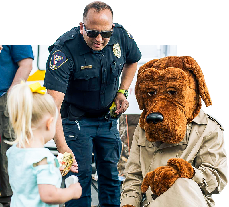 Officer Tracie Kessler and "McGruff" the crime dog hand out stickers to kids at KidFest in Beaufort, April 6. Kessler is a school resource officer with the provost marshal's office aboard Marine Corps Air Station Beaufort.